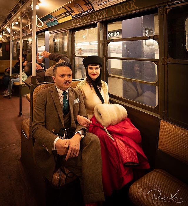 A dapper couple on the nostalgia subway train.